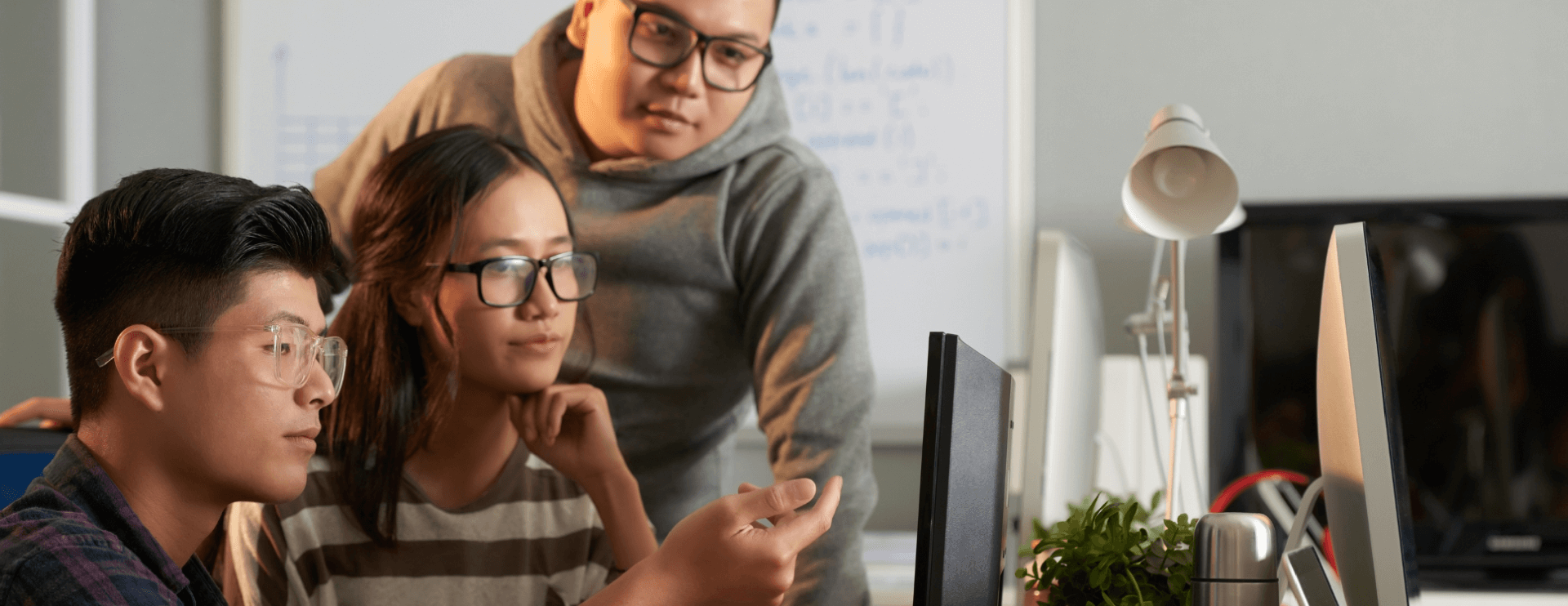 male and female students look a financial section of website on desktop screen