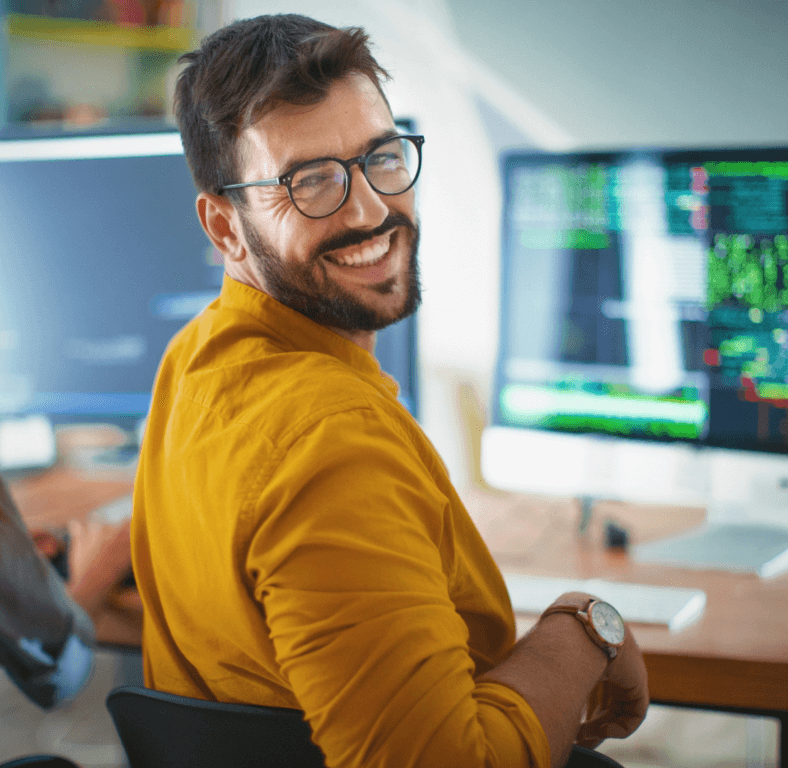 male in gold shirt turning head with great smile.