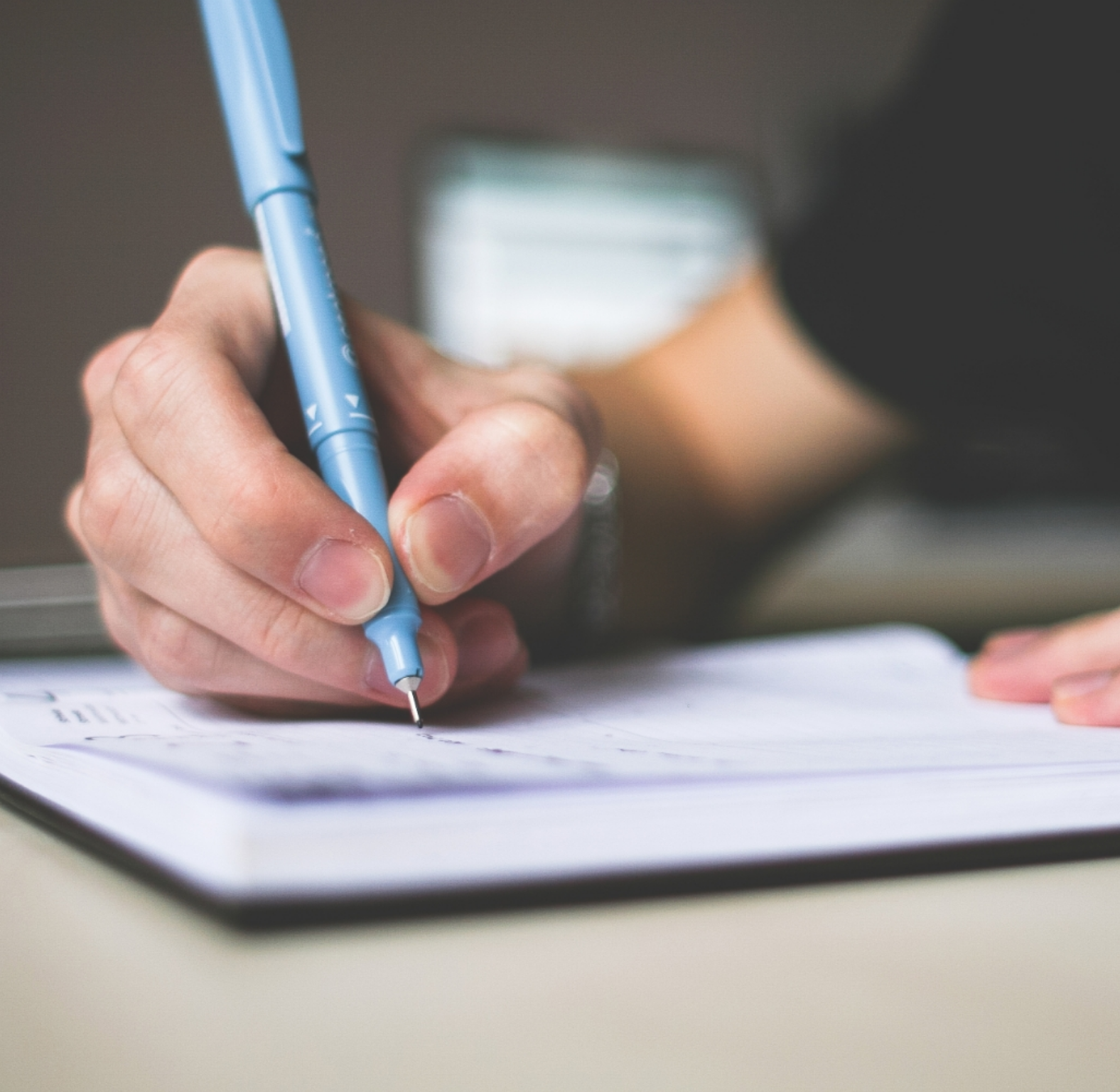 hand using pen to check off items on a checklist